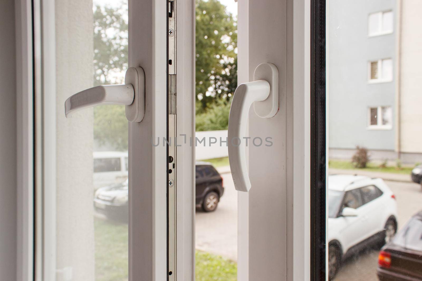 handles of opened white plastic window indoor closeup