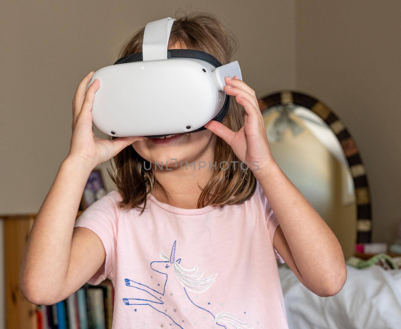 Young girl watching an app on a modern VR headset by steheap