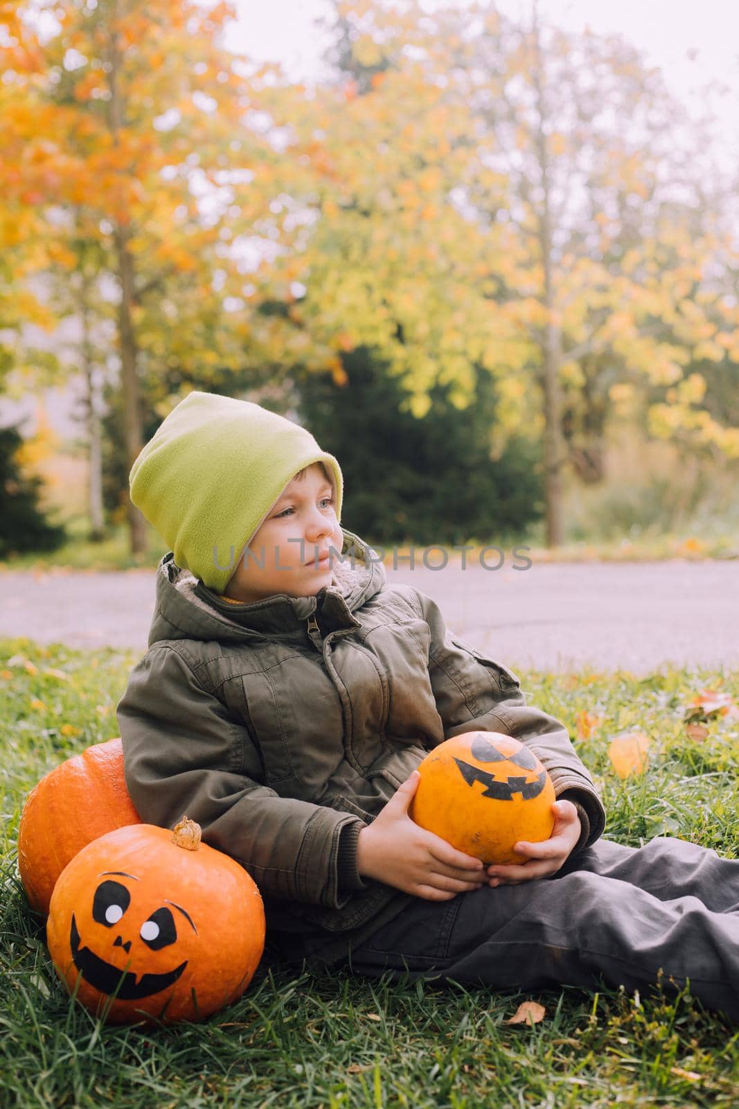 A boy with a Halloween pumpkin with eyes . The feast of fear. Halloween. An orange pumpkin with eyes. An article about Halloween.