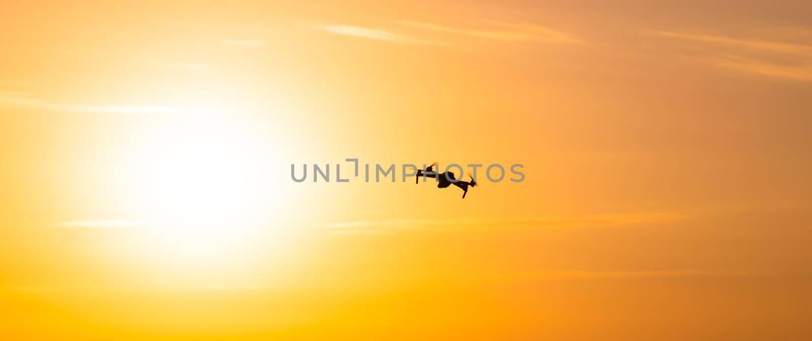 The drone is in flight at sunset . Video shooting from above. An article about the choice of a quadrocopter. Pros and cons of the drone. Sunset