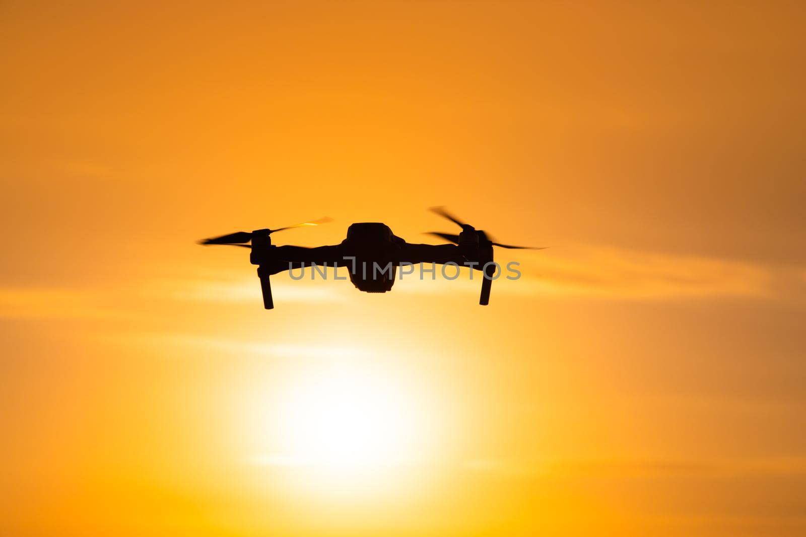 The drone is in flight at sunset . Video shooting from above. An article about the choice of a quadrocopter. Pros and cons of the drone. Sunset