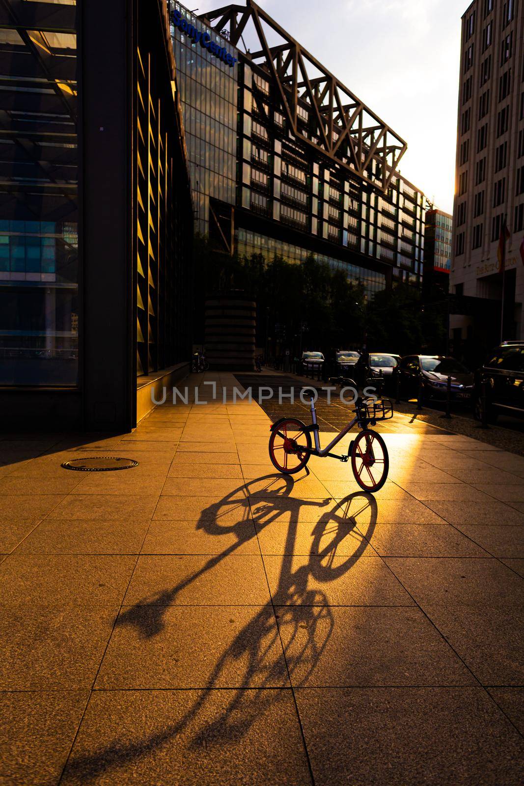 Bicycle in the light of the setting sun. City landscape.