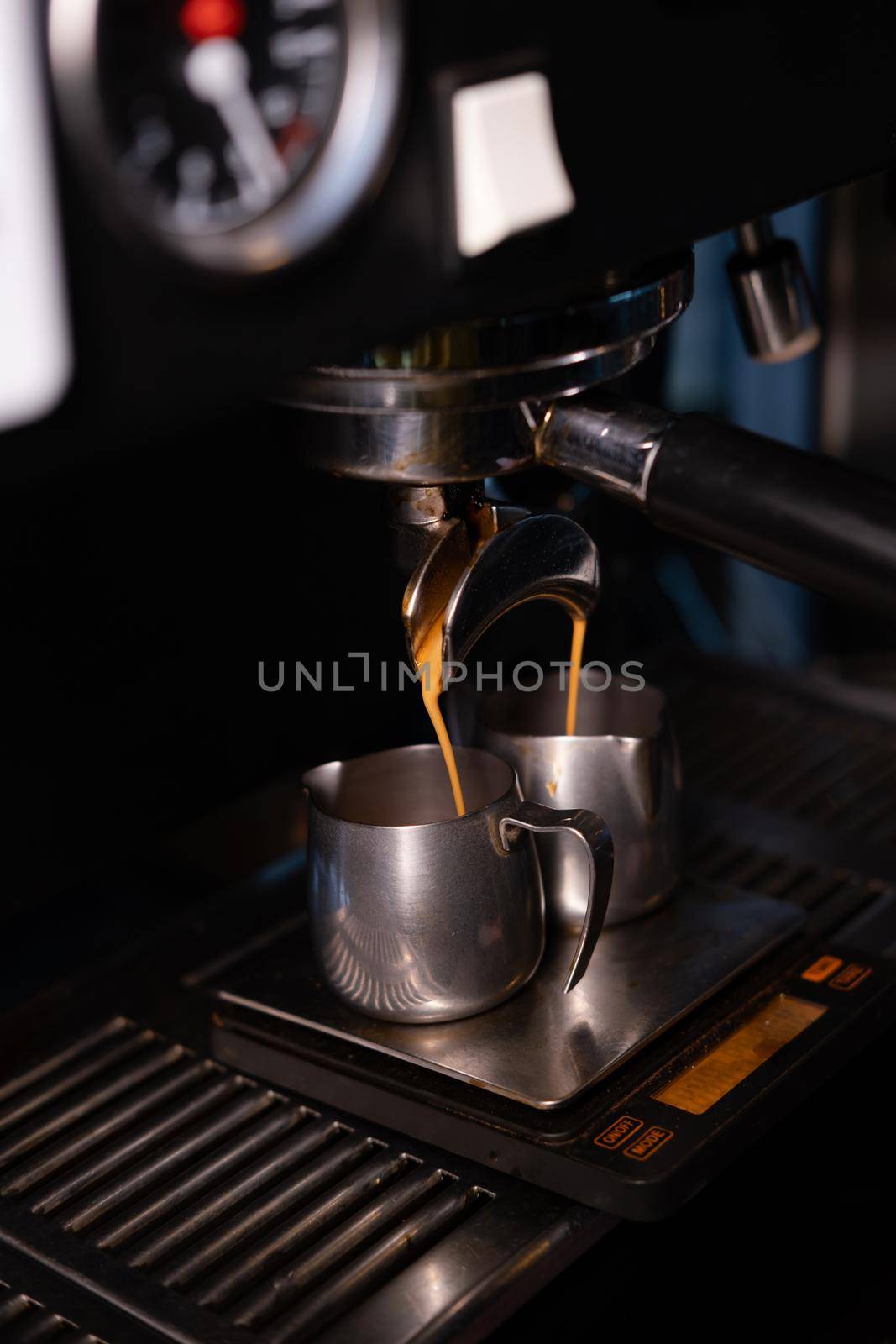 black coffee is pouring from professional coffee machine. coffee making by barista. dark loft coffee shop.