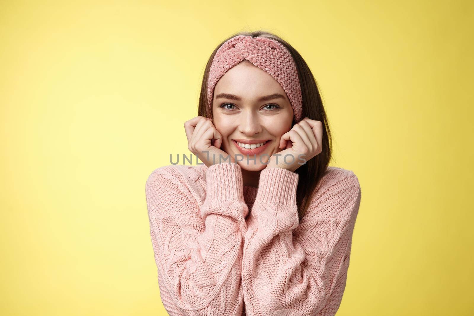 Waist-up shot of silly glamour timid girlfriend in knitted sweater shining from joy and positive emotions, holding hands on cheeks delighted and pleased blushing joyfully, standing amused.