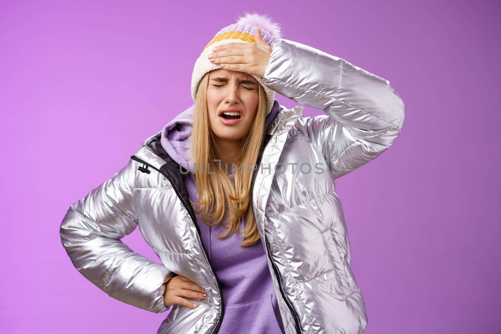 Girl sick tired touch forehead painful feeling grimacing complaining boyfriend shot snowball woman face standing bothered fed up and upset, whining displeased suffering headache, purple background.