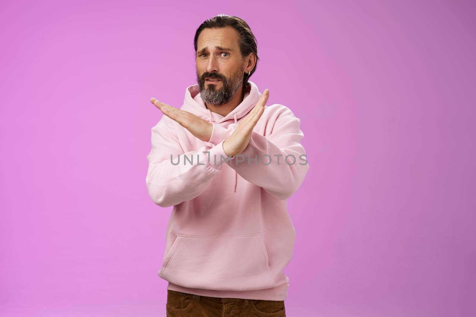 Portrait awkward displeased uncomfortable mature bearded husband begging make cross gesture refusing asking stop unwilling participate wife suspicious event standing intense express dislike by Benzoix