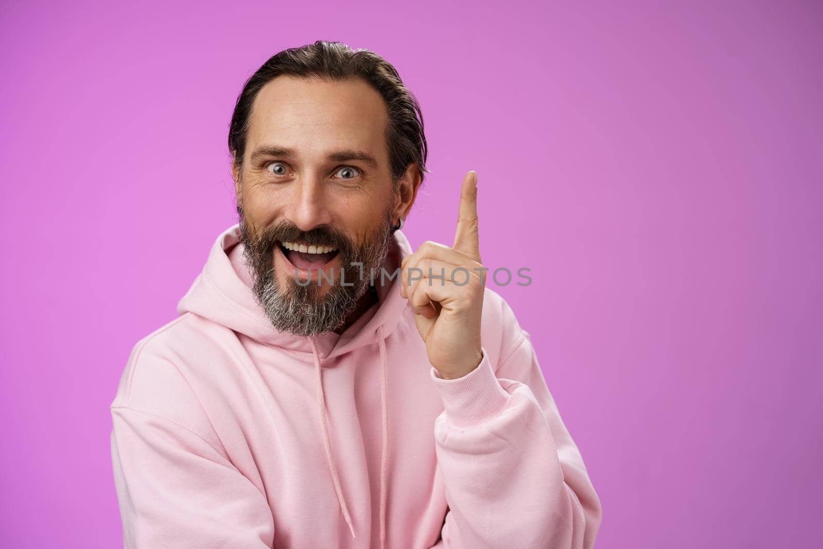 Have great idea listen. Excited energized happy charismatic male bearded guy raising index fingers add suggestion show eureka gesture smiling broadly suggesting perfect plan, purple background.
