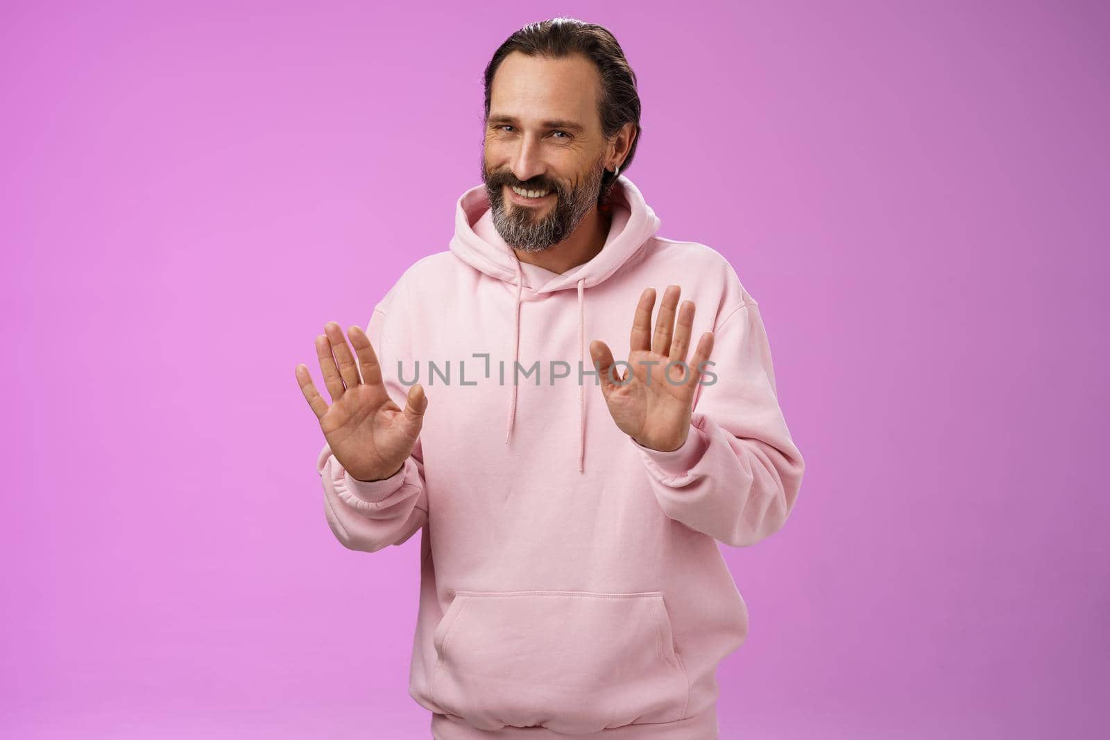 No thanks pass. Charming polite manly adult bearded man grey hair in pink hoodie apologizing refusal raise palms rejection gesture declining offer smiling say sorry not interested, purple background by Benzoix