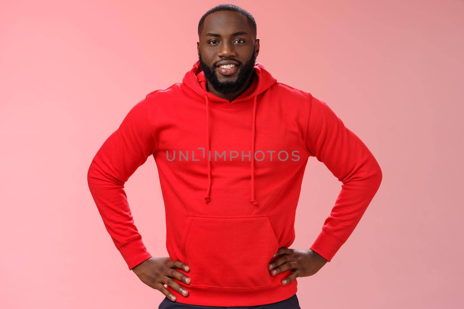 Helpful attractive friendly bearded african-american boyfriend wearing red hoodie hold hands waist smiling wanna help asking what do, lending hand, standing confident assertive pink background.