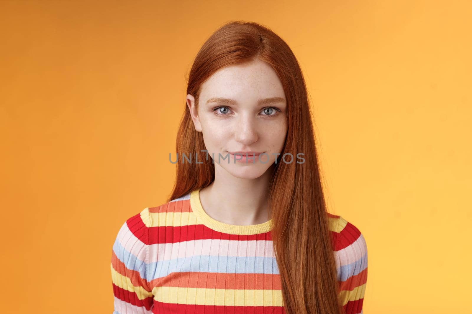 Attractive young sincere redhead girl clean pure perfect skintone smiling modest look camera friendly delighted standing relaxed awaiting gazing silly tenderly, posing orange background by Benzoix