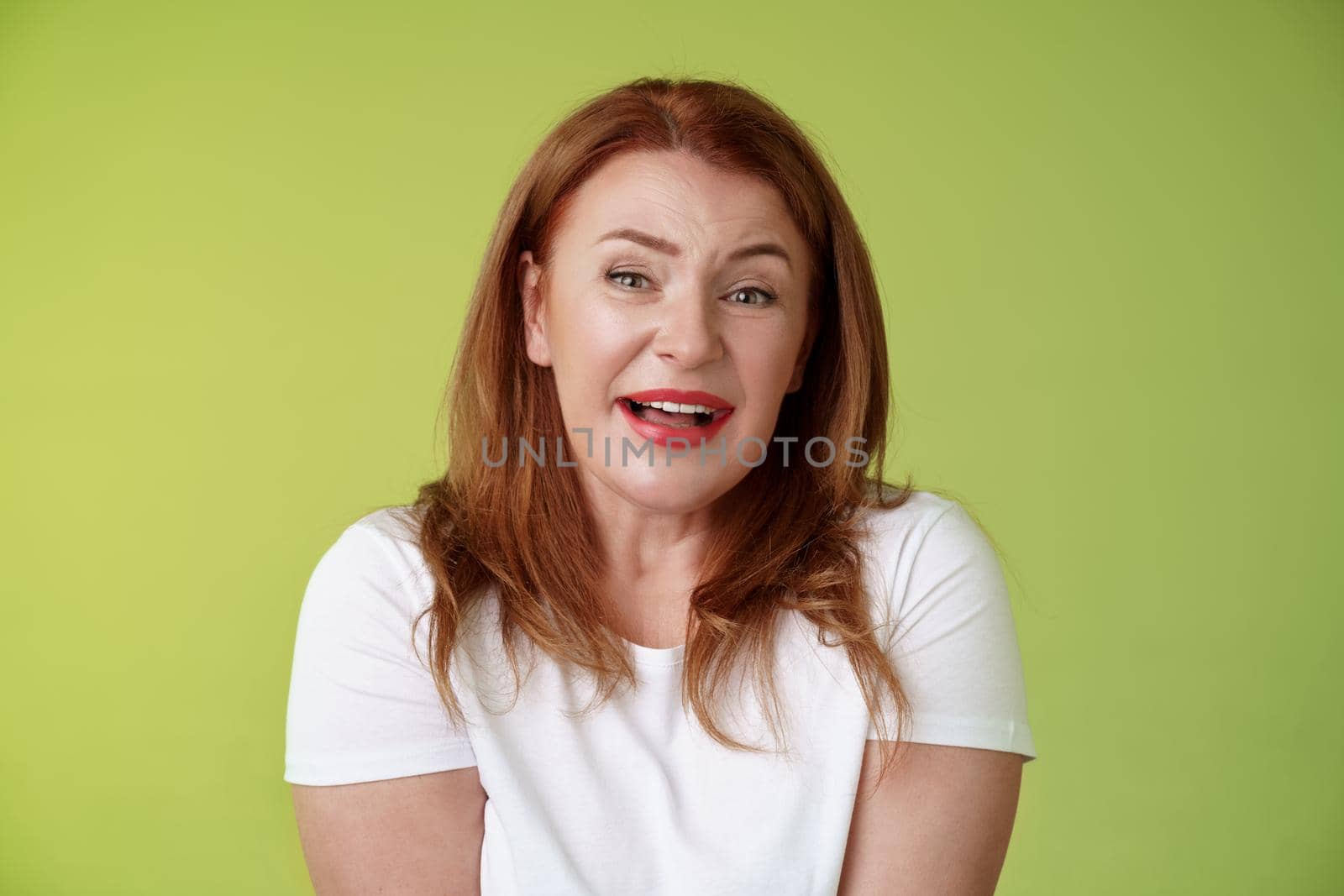 Tender redhead cheerful middle-aged mother sighing happiness temptation smiling delighted look alluring fascinated camera check out cute lovely scene melting heartwarming moment green background.