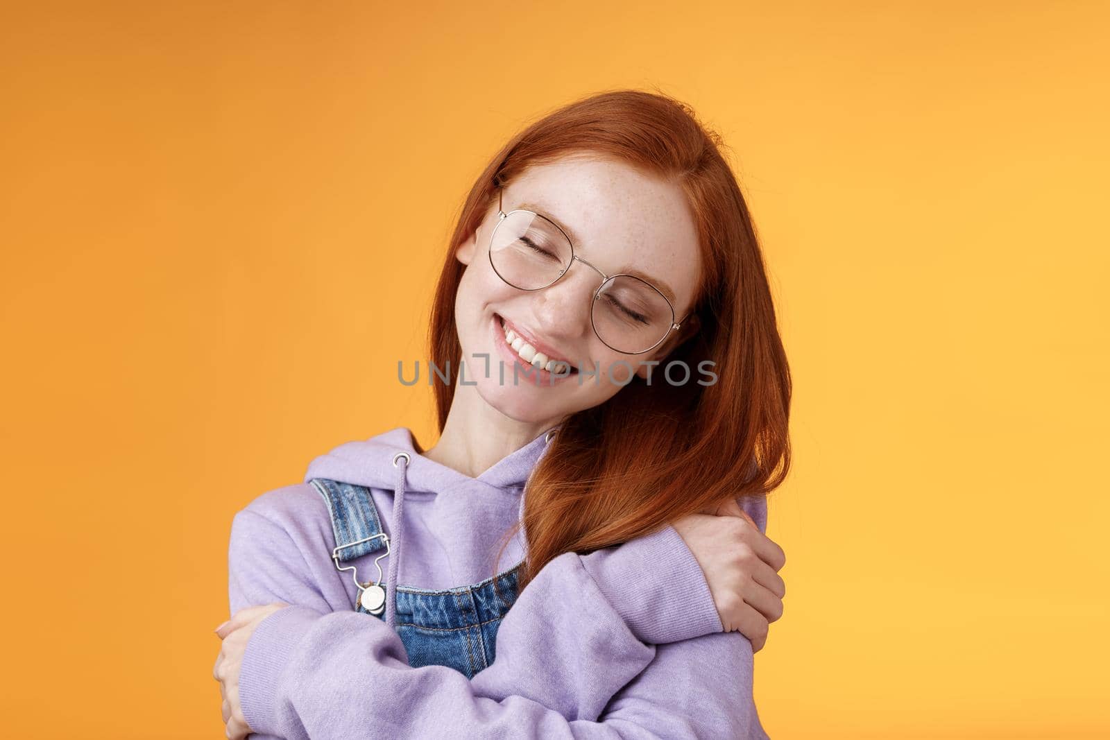 Close-up romantic lovely charming redhead girl enjoy warmth love tilting head close eyes dreamy imaging perfect date hugging herself embracing own body accept body-positivity orange background by Benzoix