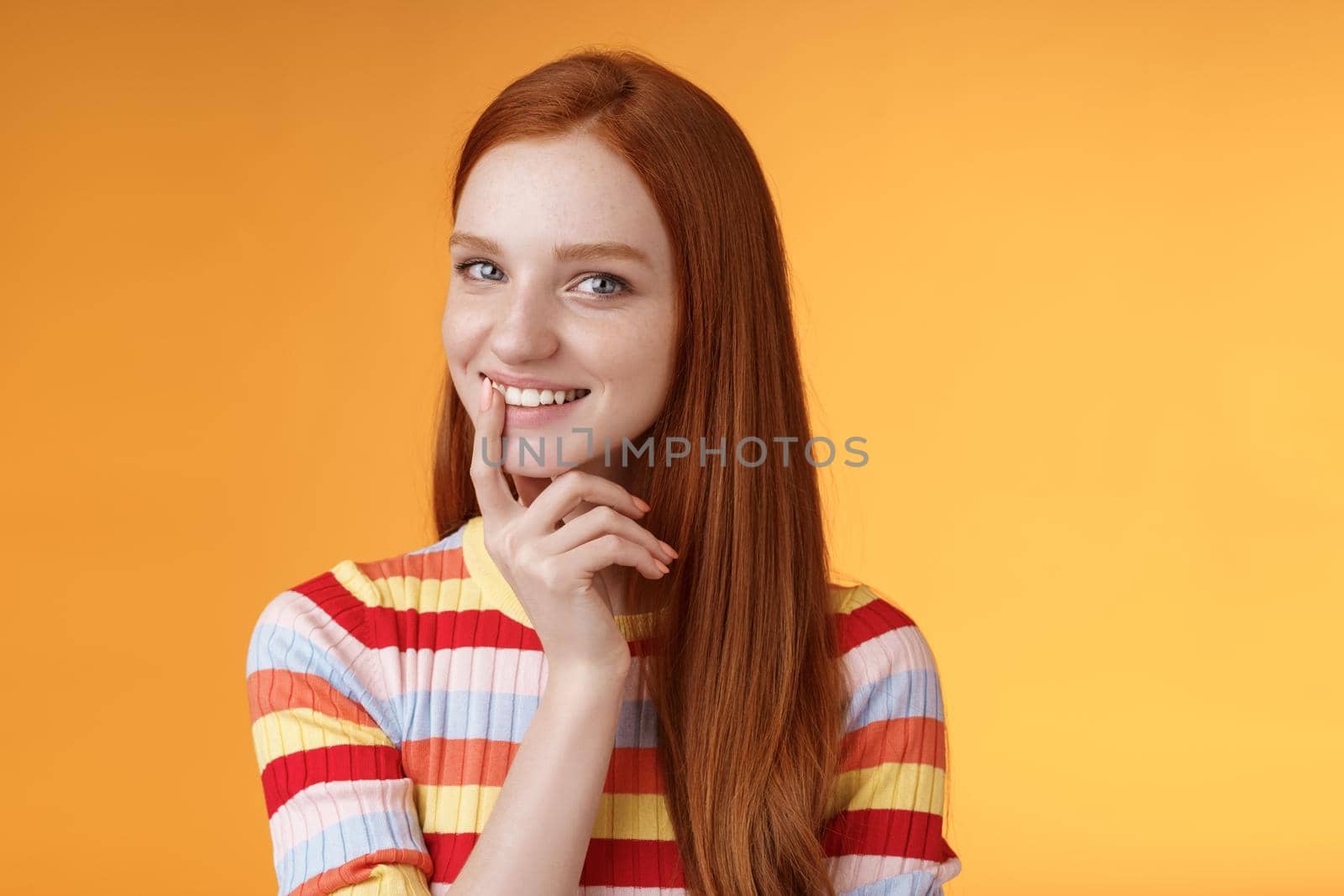 Curious devious redhead young 20s girlfriend have excellent idea smirking tricky touch lip flirty mysteriously glancing camera have plans preparing interesting surprise, standing orange background.