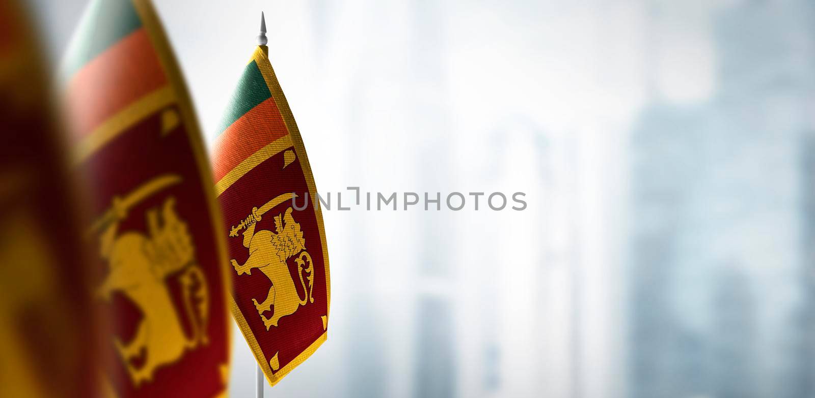 Small flags of Sri Lanka on a blurry background of the city.