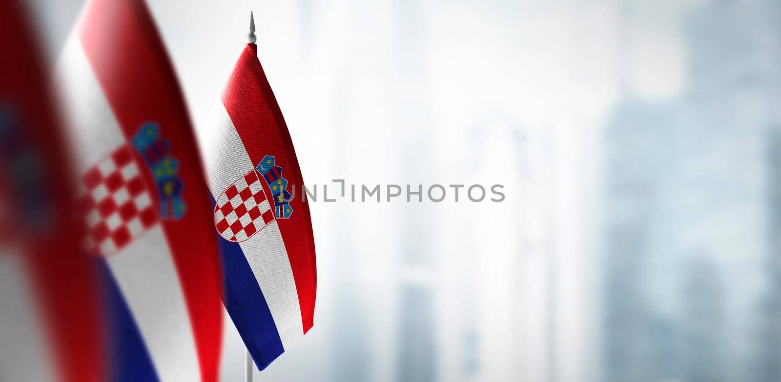 Small flags of Croatia on a blurry background of the city.