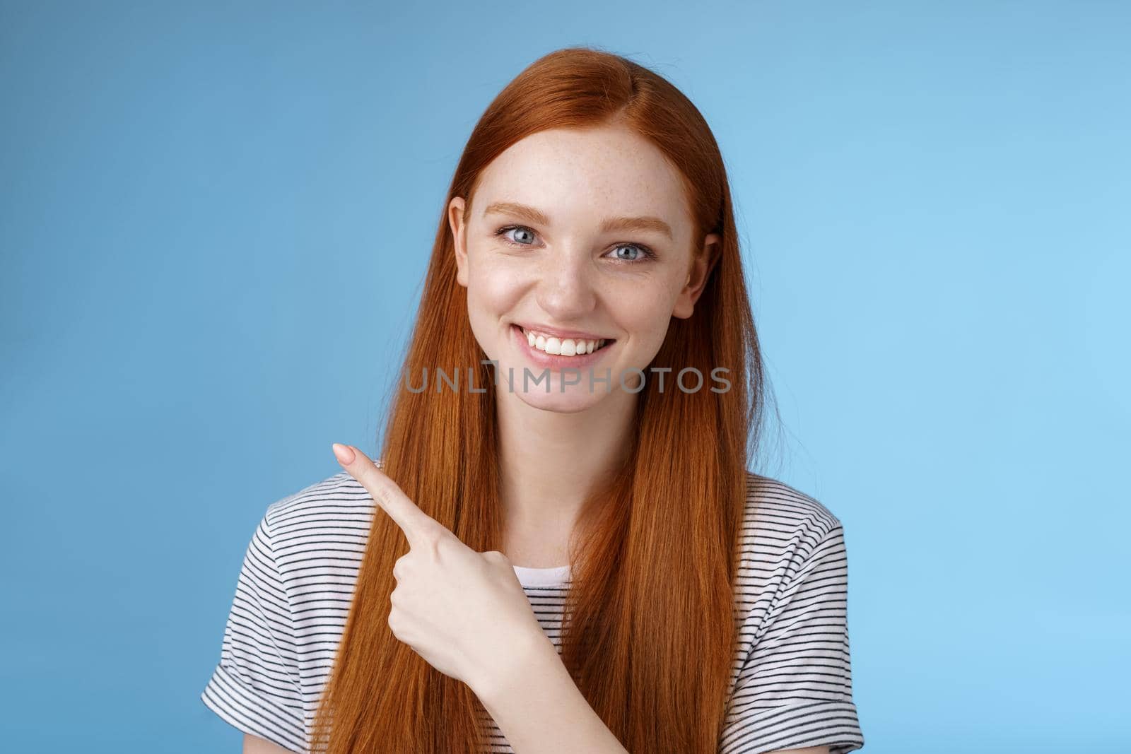 Close-up attractive gentle tender friendly-looking smiling redhead woman show place pointing upper left corner index finger grinning helpful giving choice help find store, standing blue background.