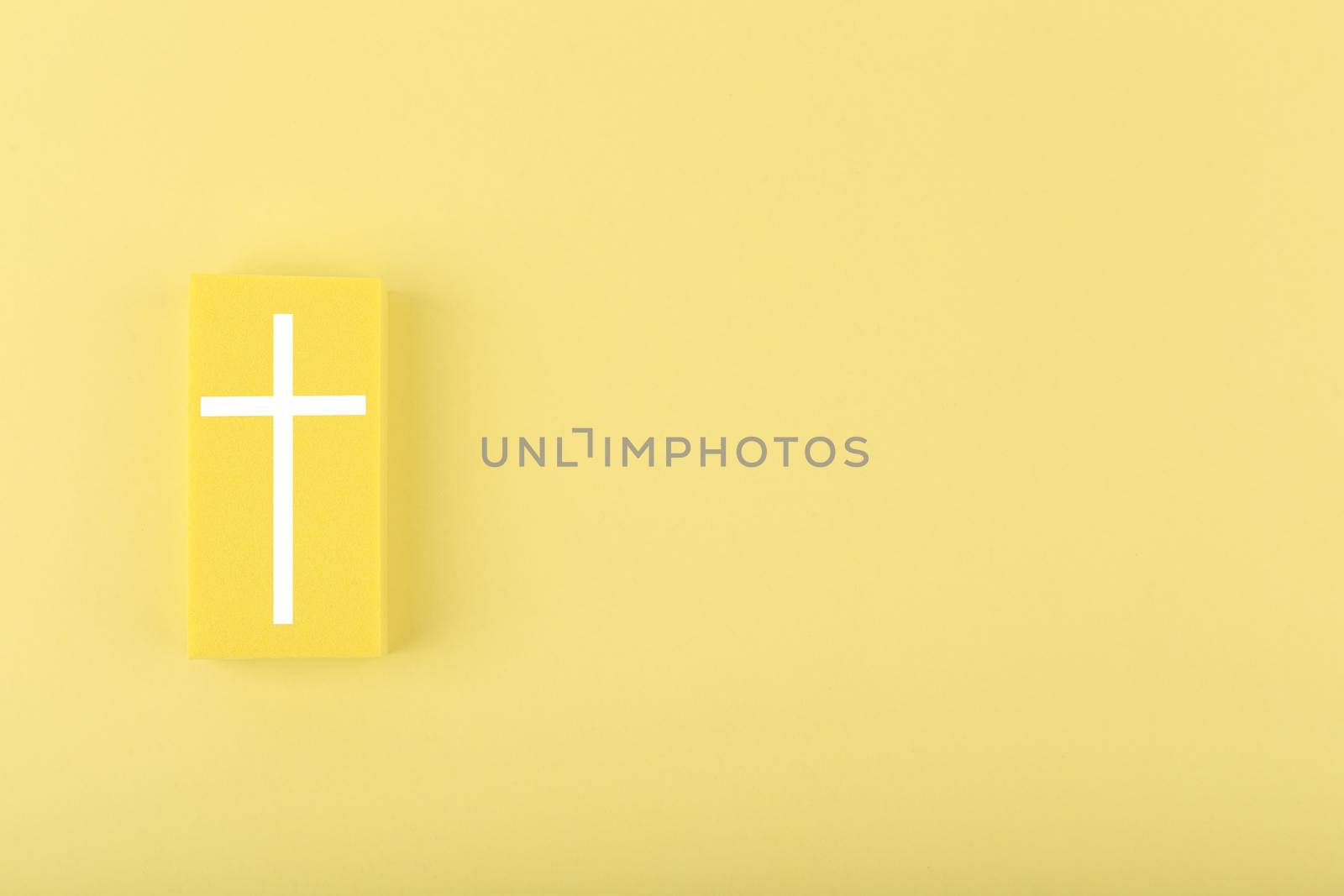 Modern religious minimal concept of hope with christian cross on bright yellow background with copy space by Senorina_Irina