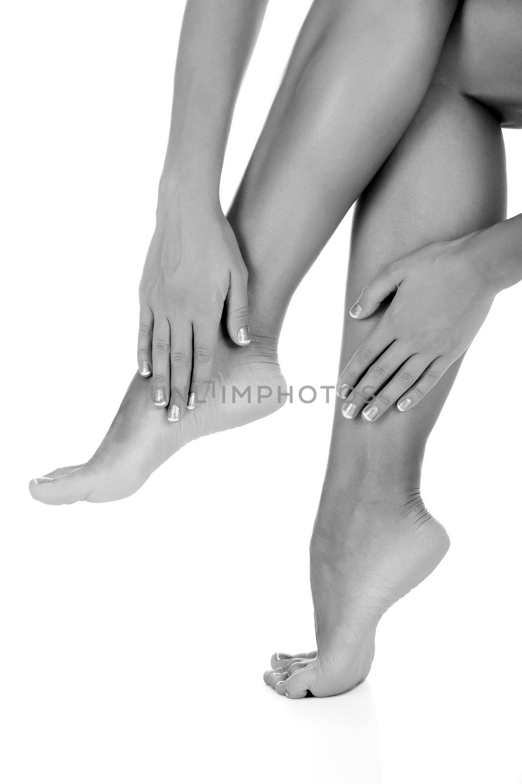 Woman touches her leg, white background, copyspace