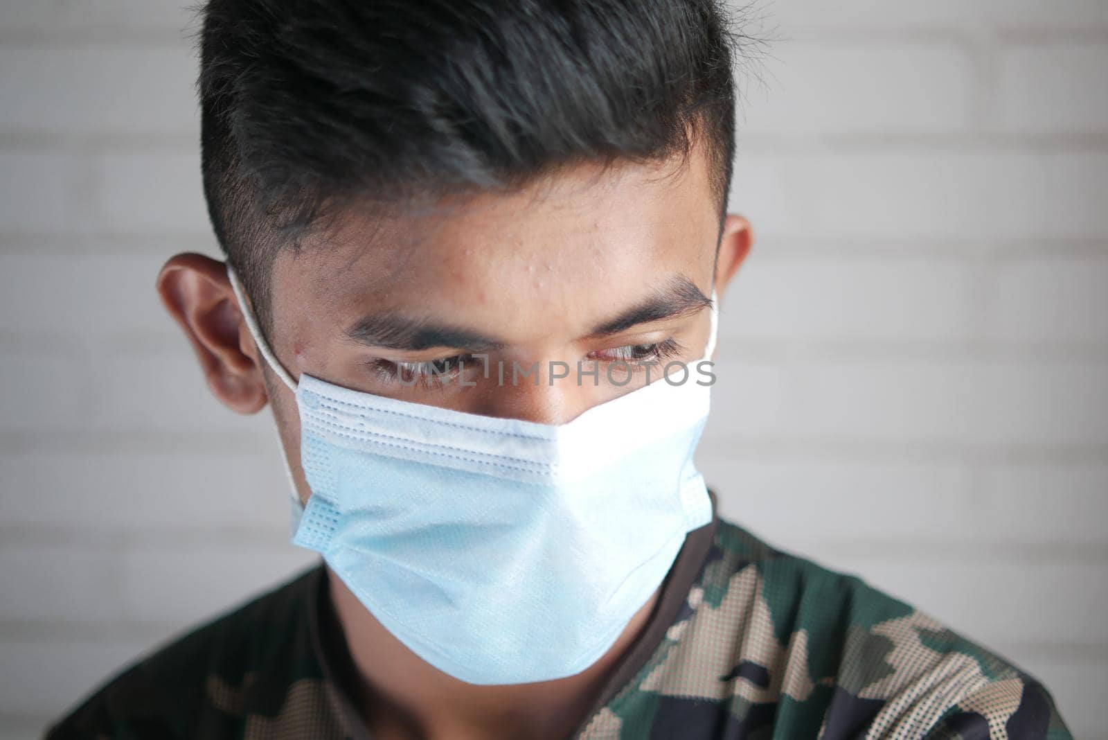 Close up of man with protective face mask looking at camera.