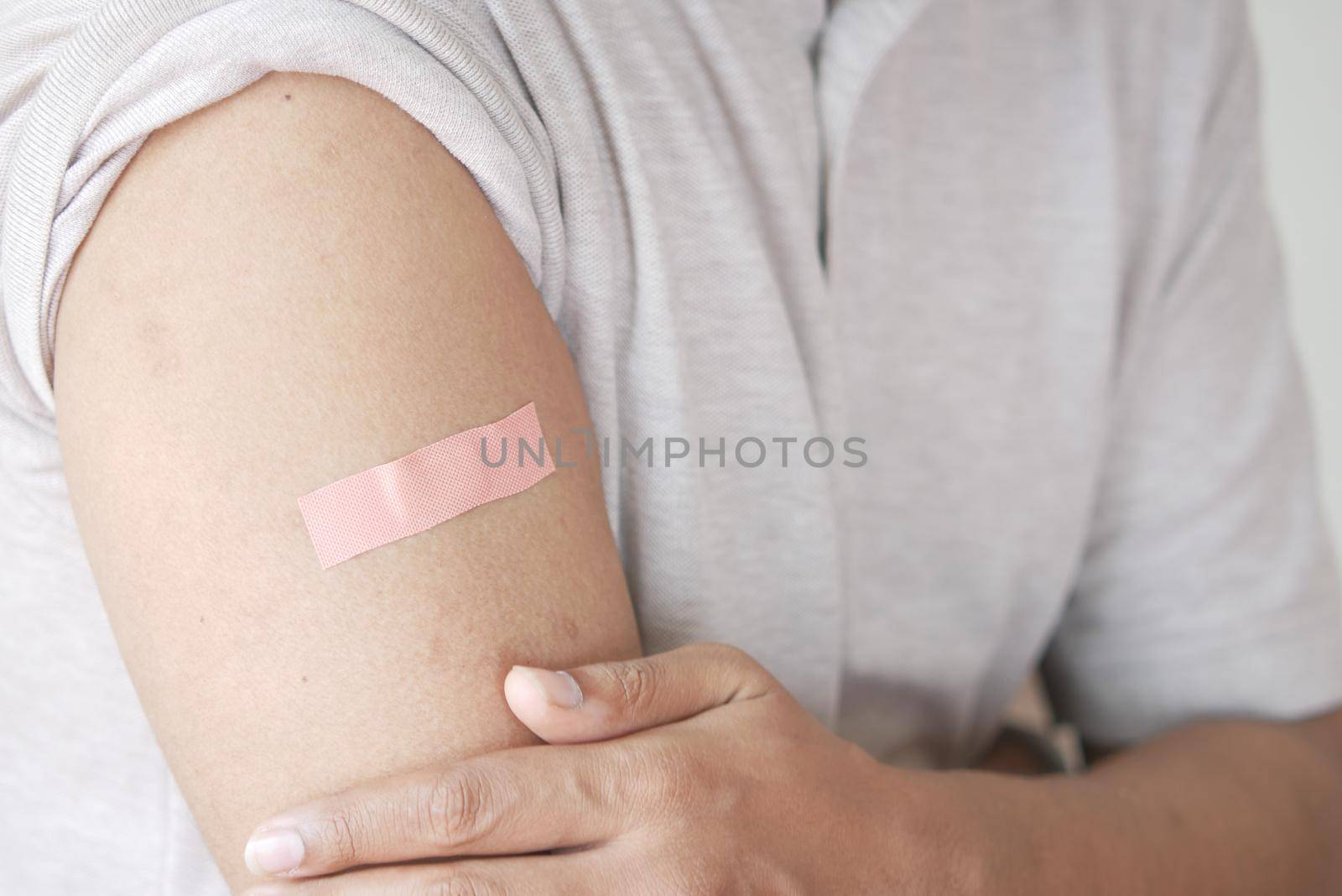 adhesive bandage on young man's arm .