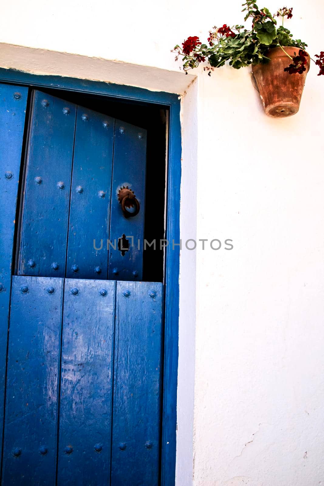 Typical Andalusian whitewashed facade with blue painted wooden door in Mojacar