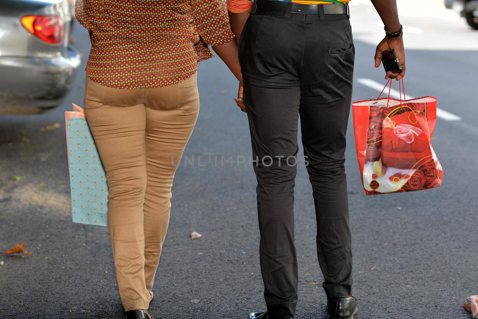 young african couple in pants walking on the street