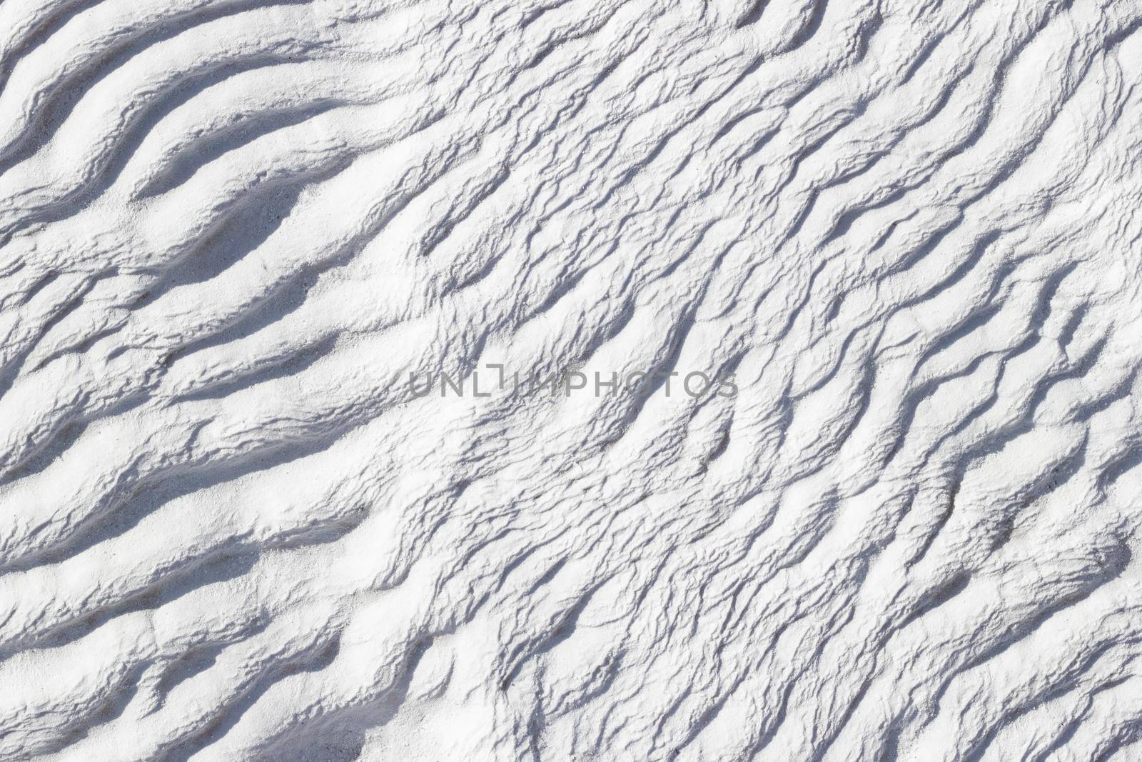 White abstract texture of Pamukkale calcium travertine in Turkey, asymmetric pattern close-up.