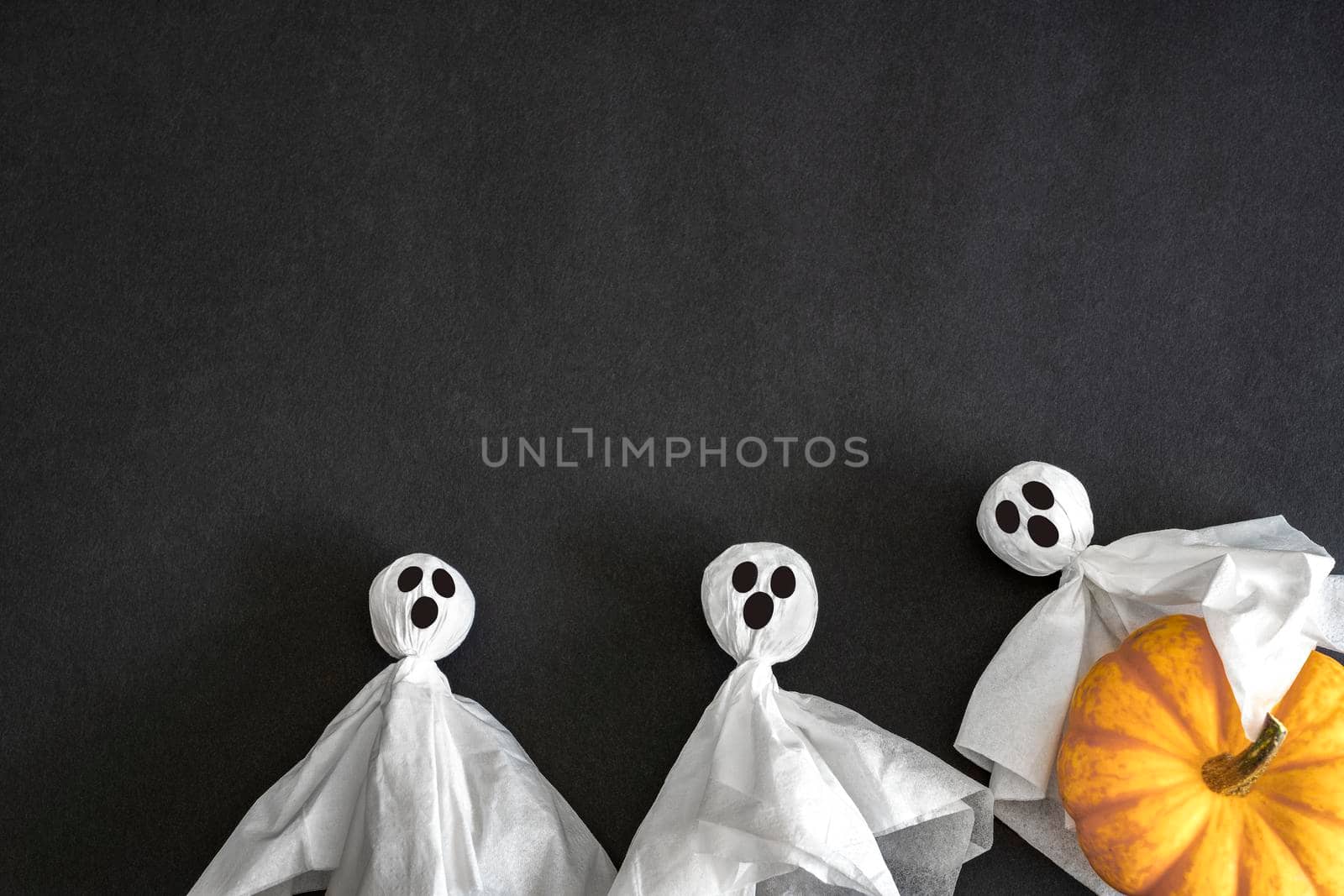 Two ghosts. pumpkin on black background, top view. Copy space. Halloween Concept.