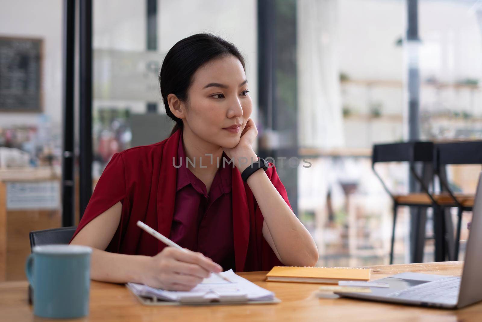 Portrait of cheerful asian woman with casual life on desk in home office. Concept of young business people working at home. by itchaznong
