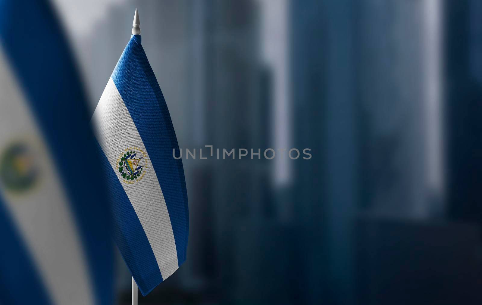 Small flags of Salvador on a blurry background of the city.
