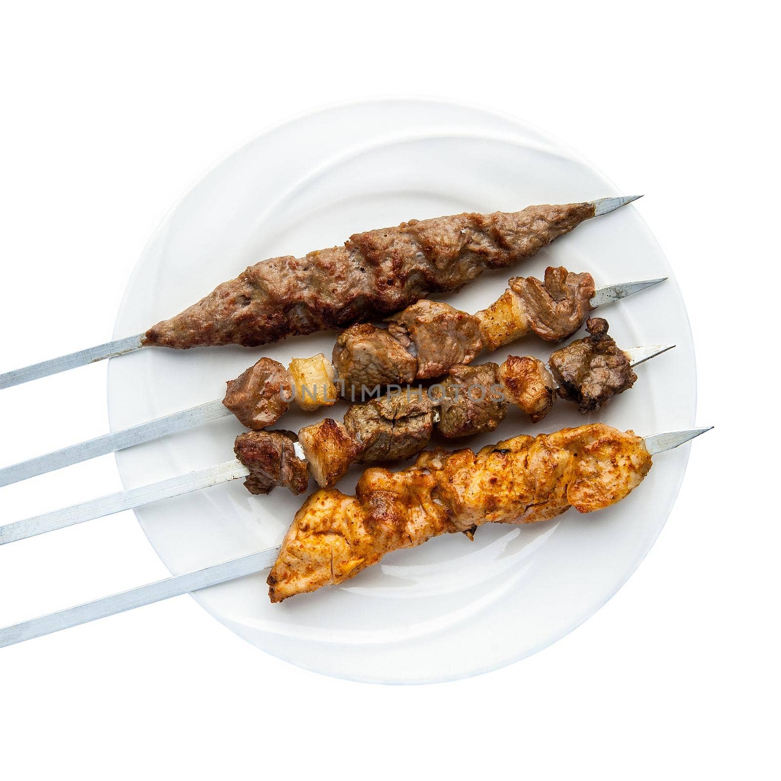 Kebab on skewers in a plate on a white background. Top view. Isolated. Barbecue