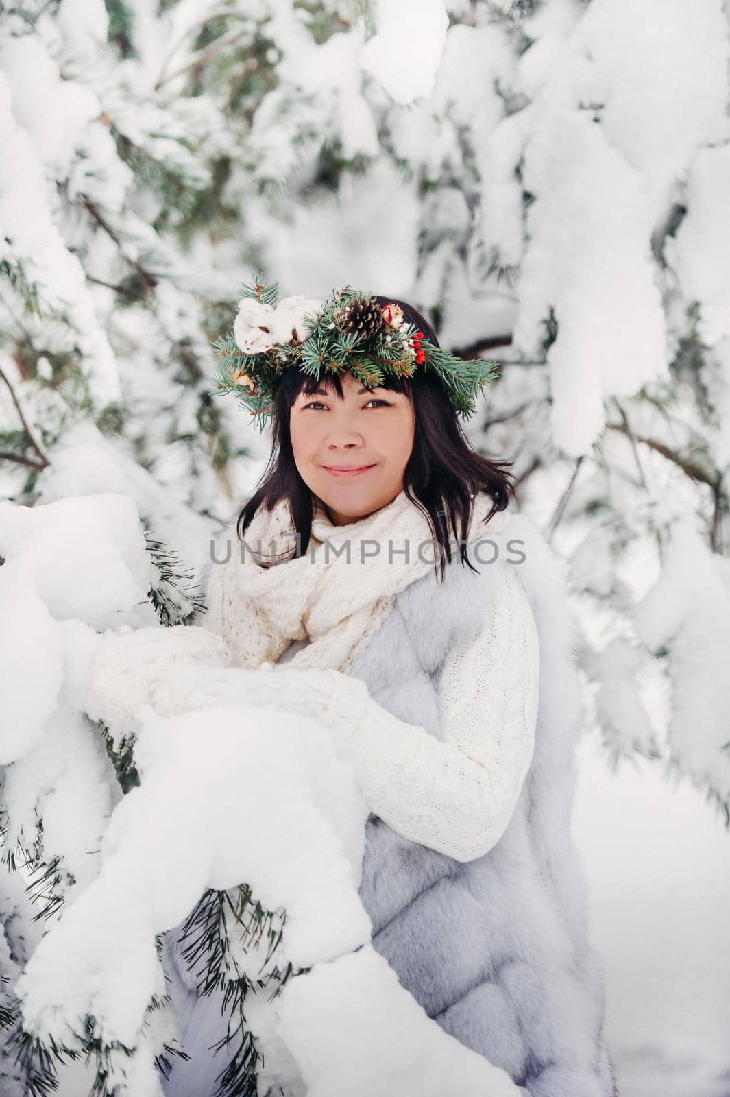 Portrait of a woman in white clothes in a cold winter forest. Girl with a wreath on her head in a snow-covered winter forest by Lobachad