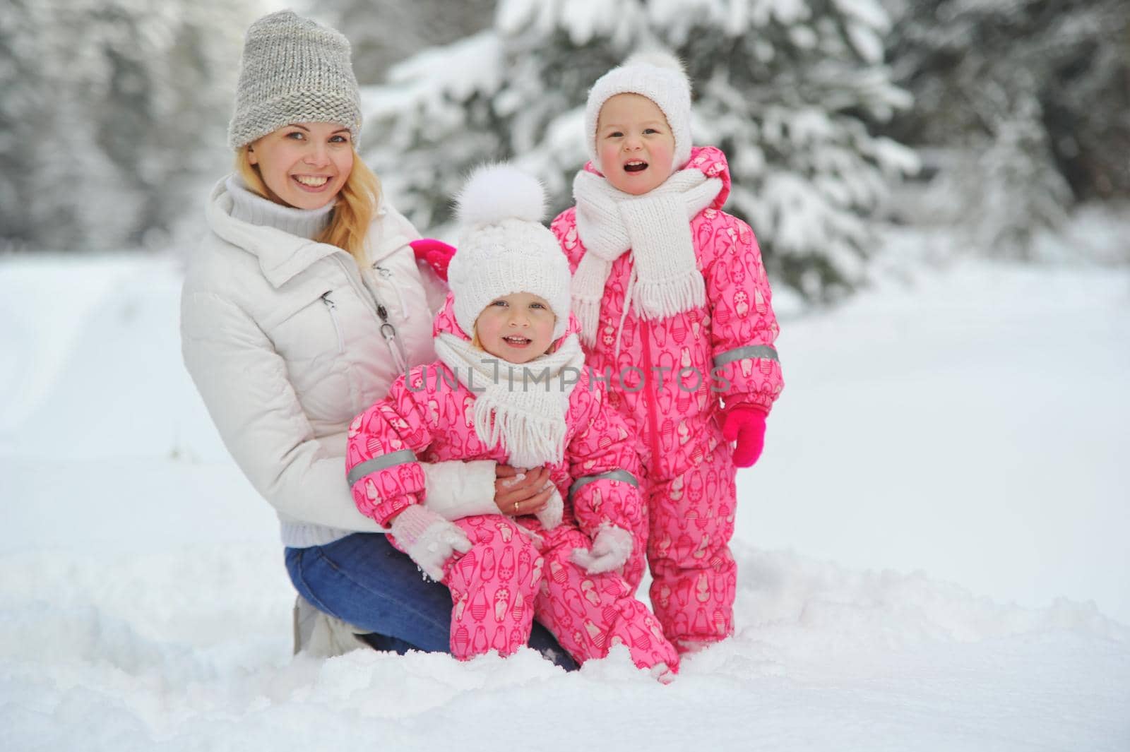 Mom and children on a walk in the winter in the forest.