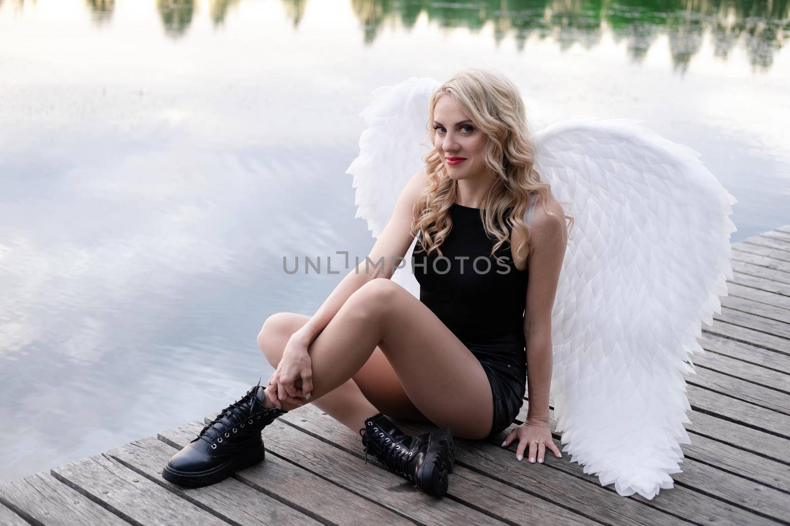 fallen angel. girl in black with white angel wings