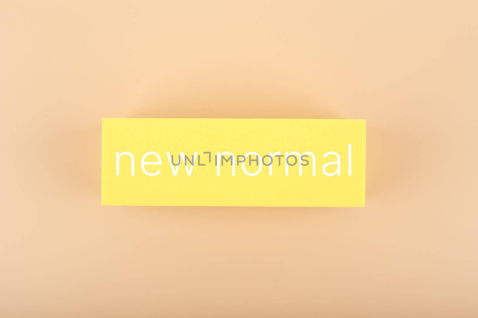 New normal concept. Text on yellow rectangle against pastel beige background. High quality photo