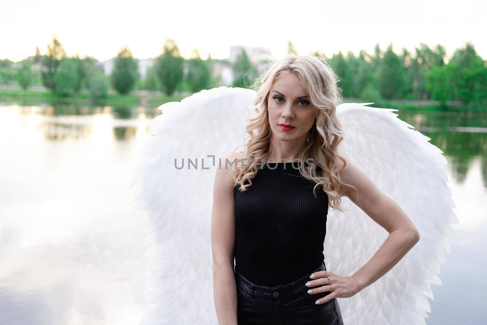 fallen angel. girl in black with white angel wings