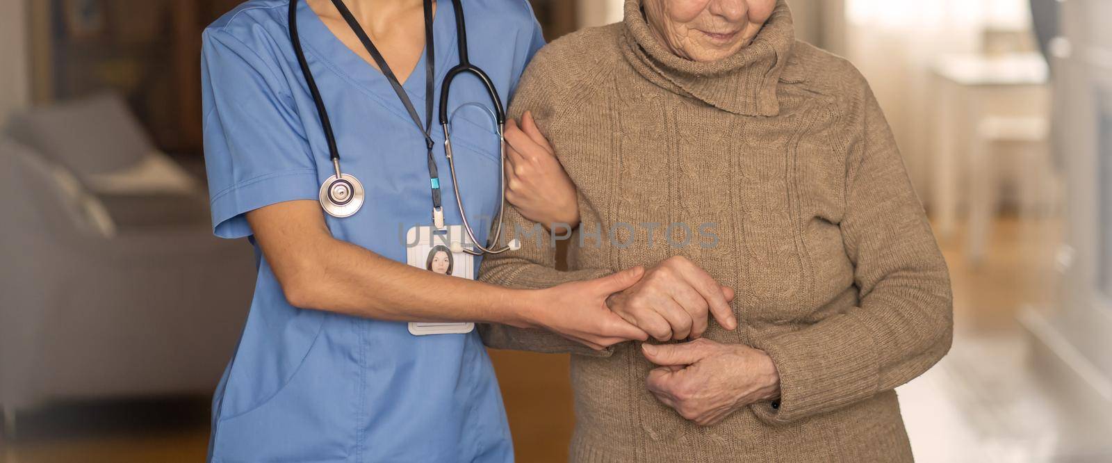 A young nurse shows care and professionalism in relation to an elderly woman, a pensioner. Young woman doctor visits the patient at home and conducts medical therapy