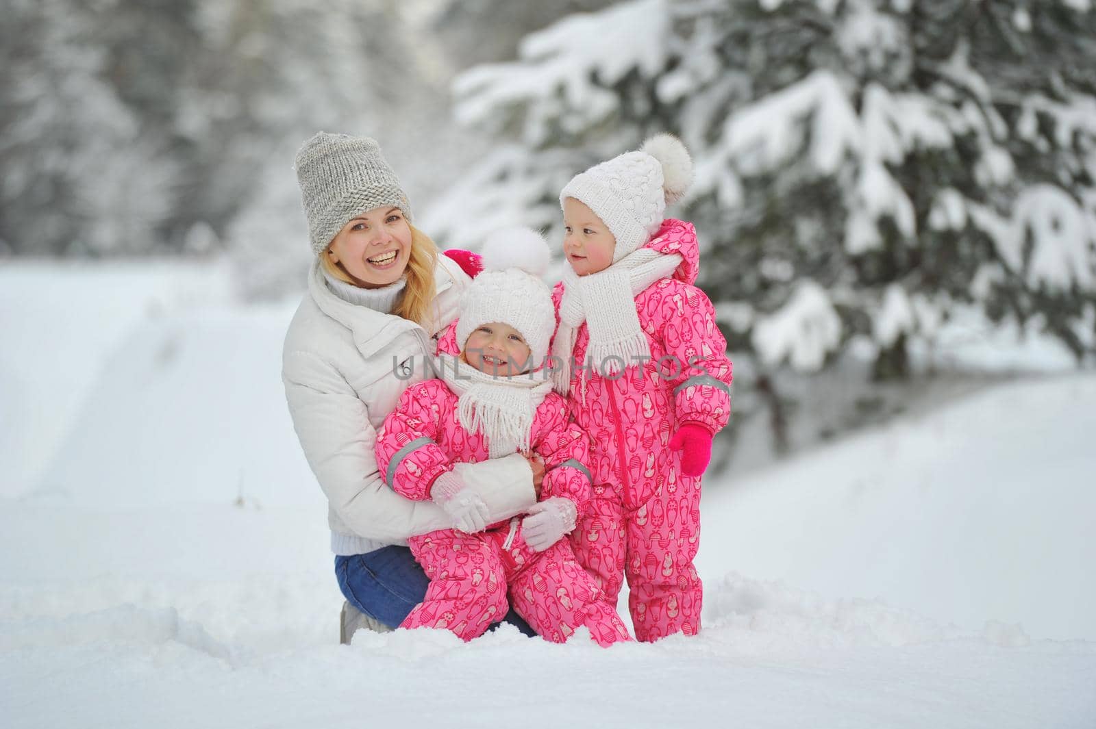 Mom and children on a walk in the winter in the forest.