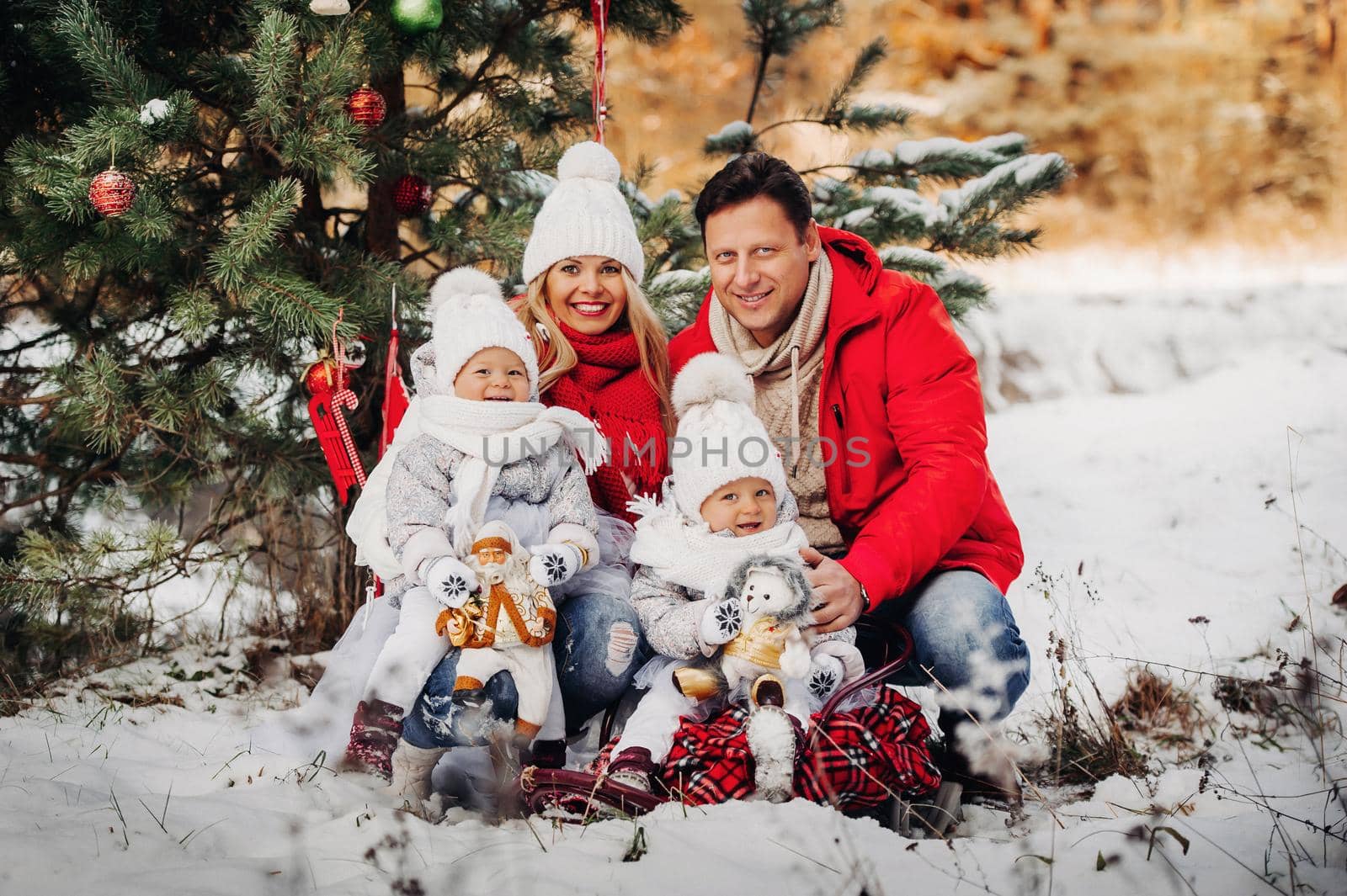 A large family with children at the Christmas tree on the street Happy Children with gifts.