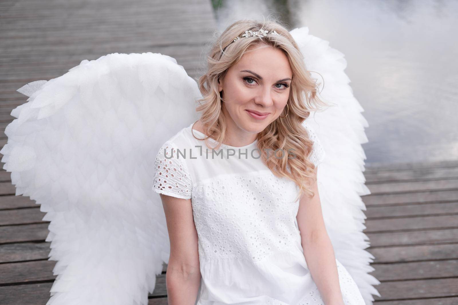 woman with white angel wings. beautiful blonde in angel costume. heaven, purity. good person.