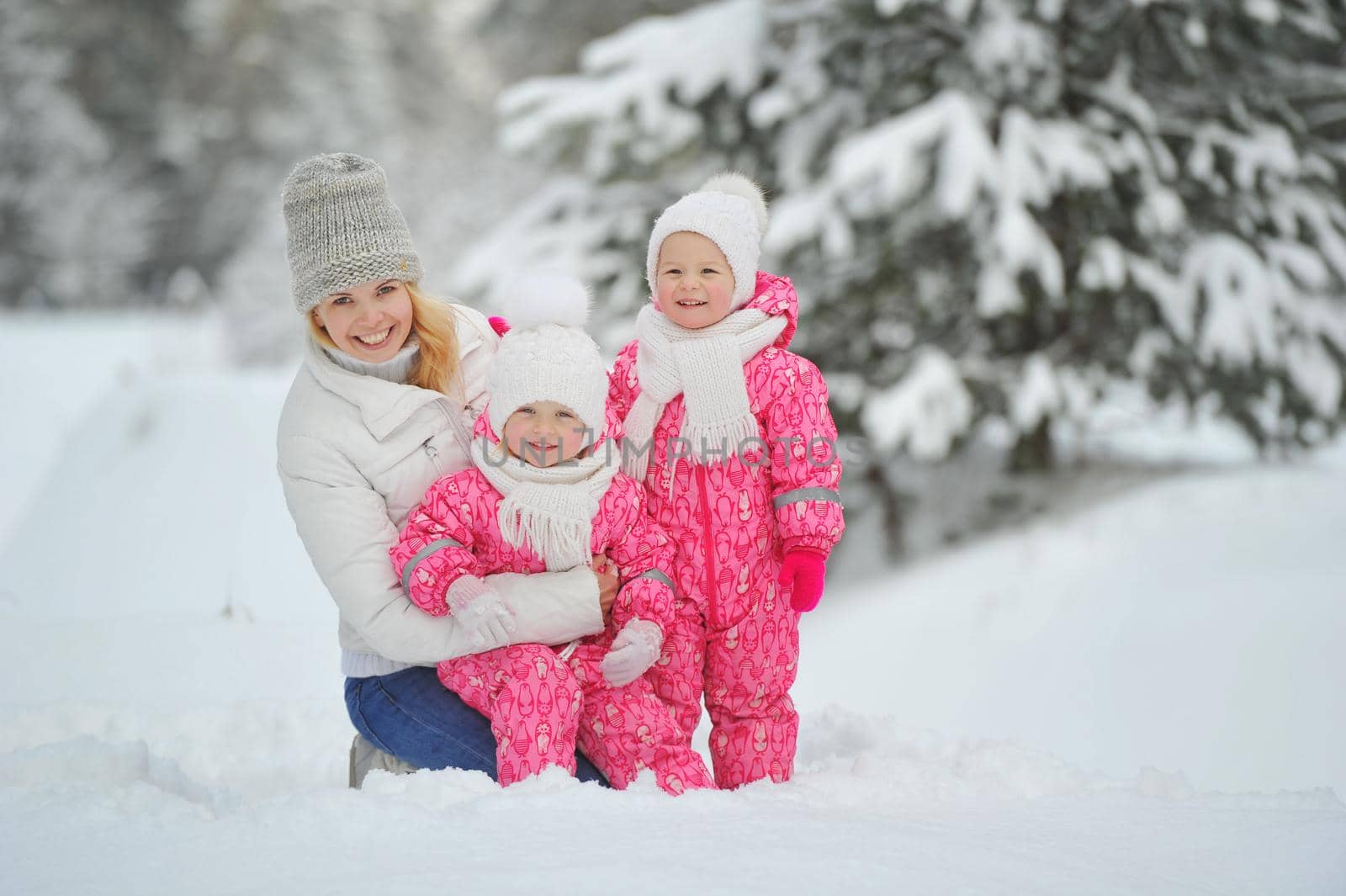 Mom and children on a walk in the winter in the forest.