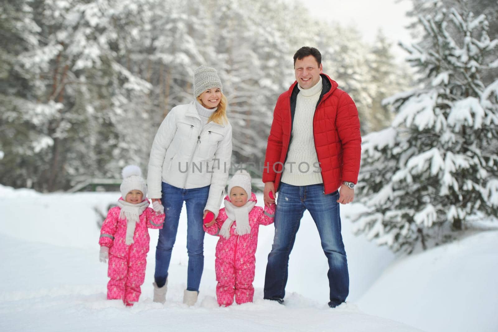 A large family with children on a walk in winter in the forest.