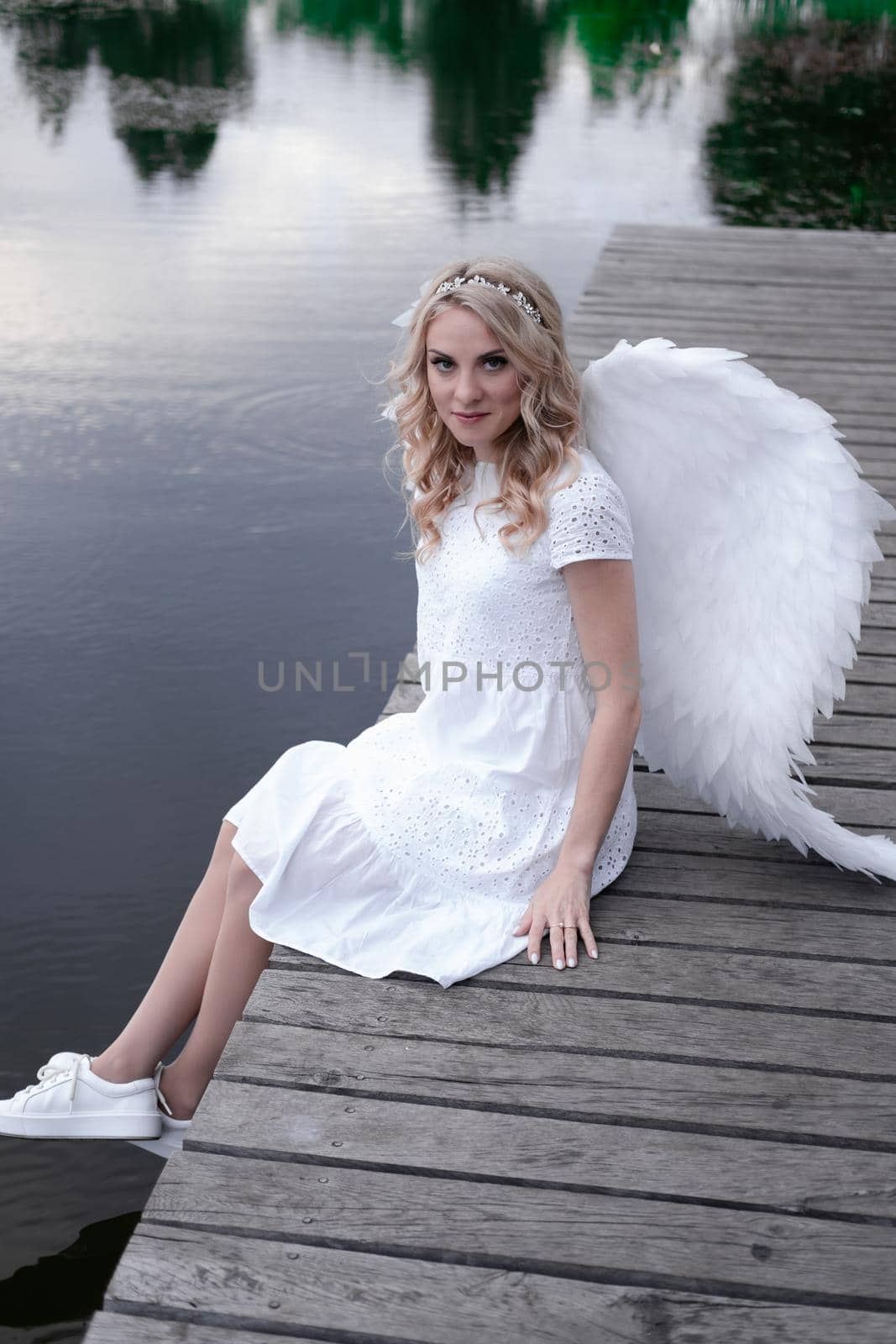 woman with white angel wings. beautiful blonde in angel costume. heaven, purity. good person.