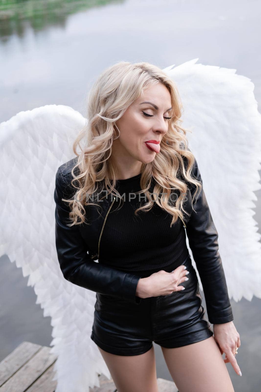 portrait of a sensitive woman with white angel wings. wearing black leather clothes. fallen dark angel. demon. beast