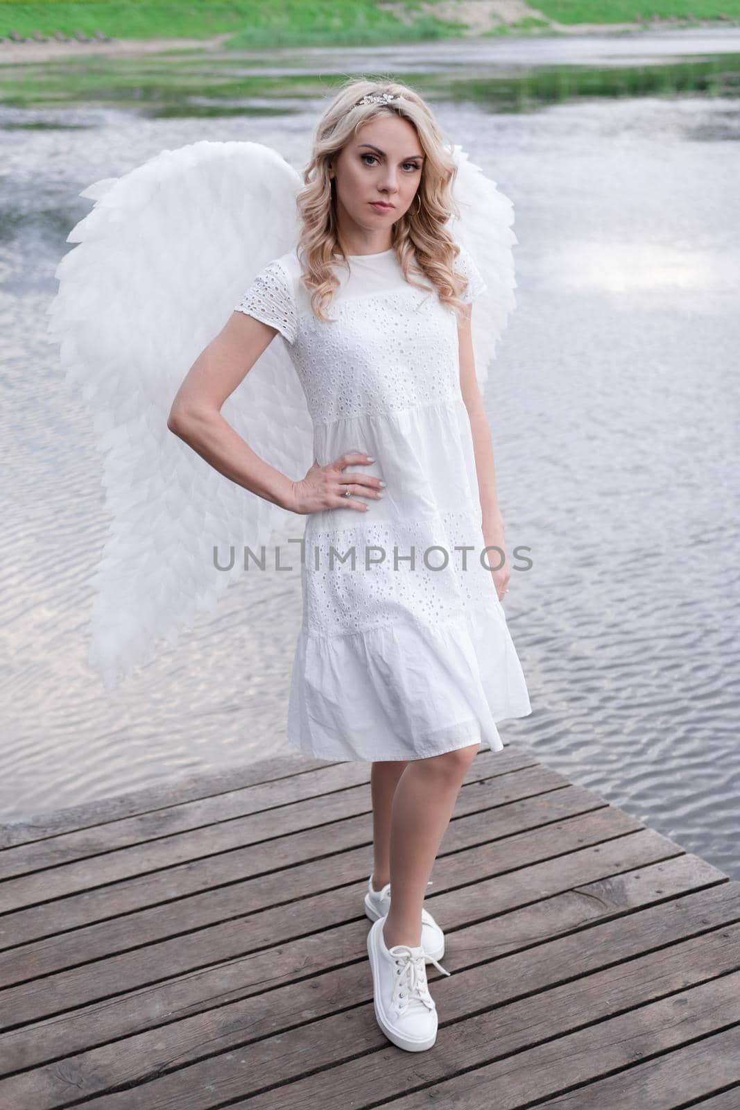 woman with white angel wings. beautiful blonde in angel costume. heaven, purity. good person.