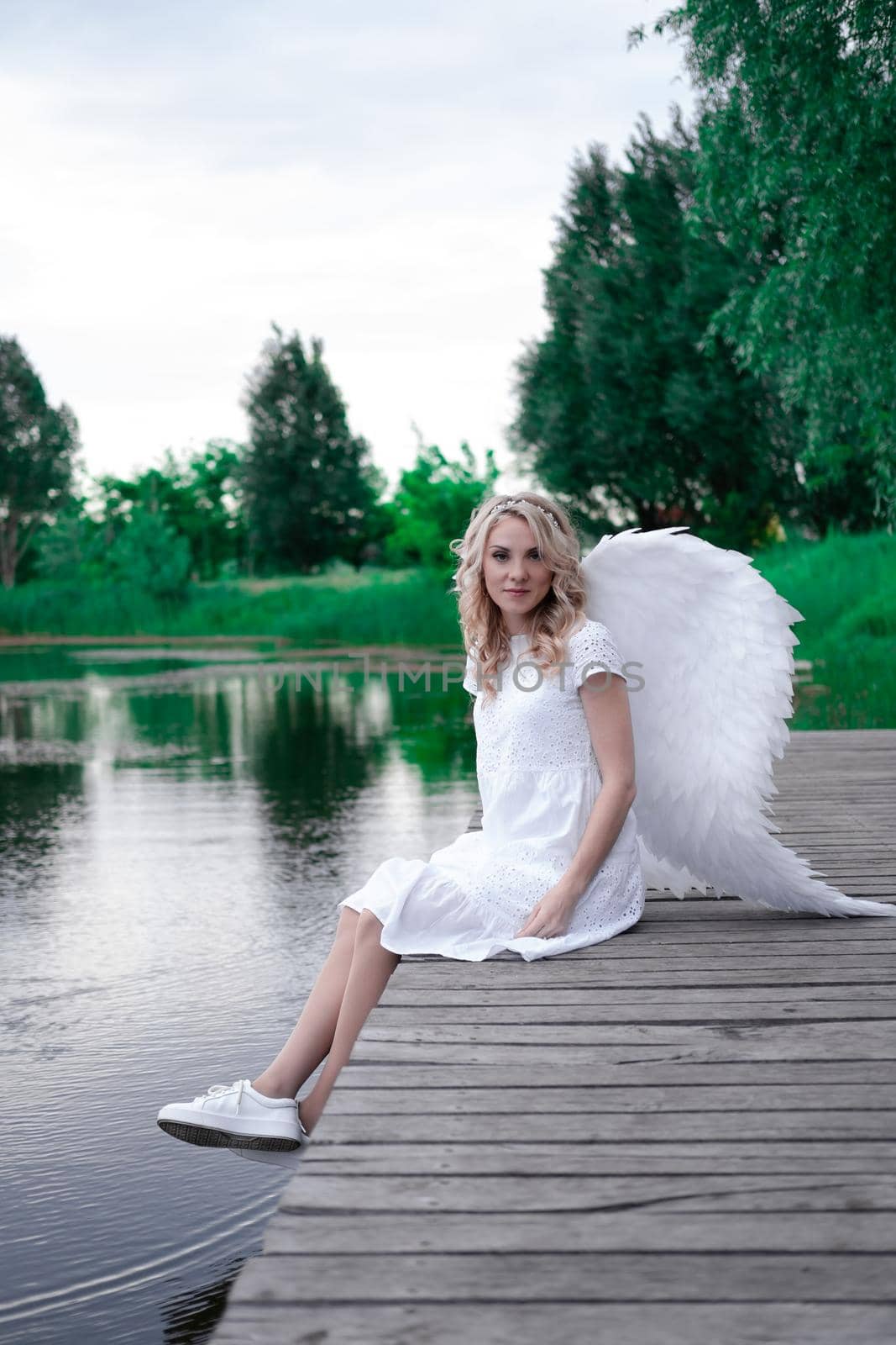 beautiful angel in white dress. Amazing blond woman with long curly hair and white wings. by oliavesna