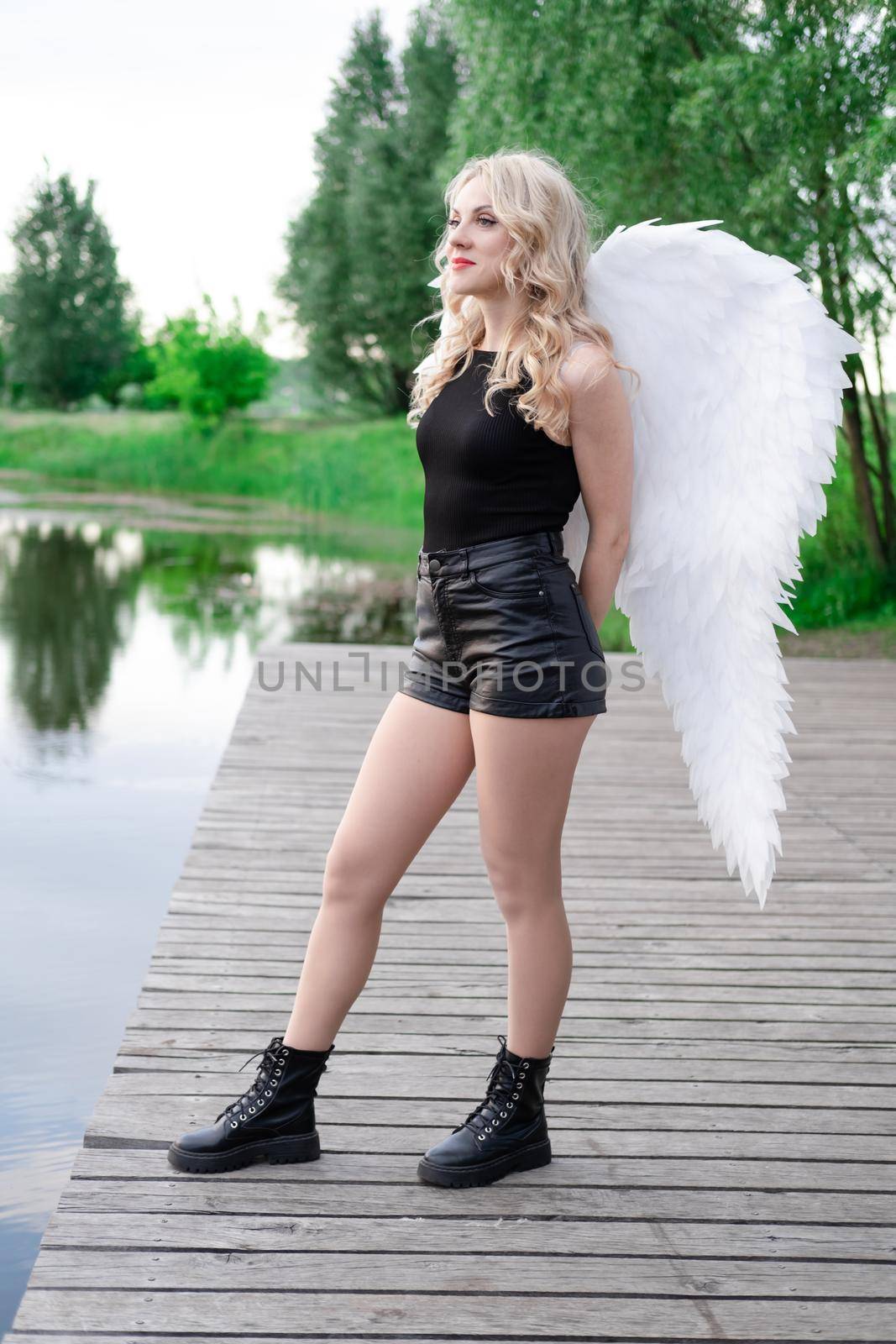 fallen angel. girl in black with white angel wings