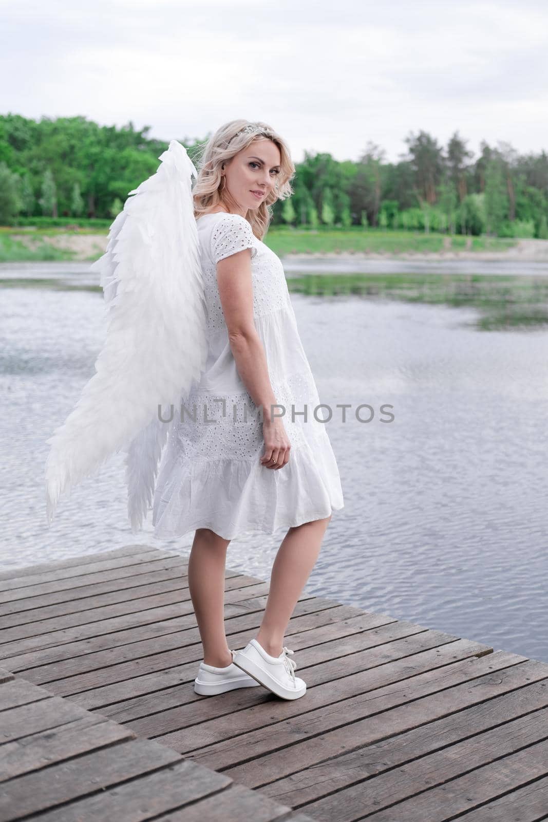 woman with white angel wings. beautiful blonde in angel costume. heaven, purity. good person.