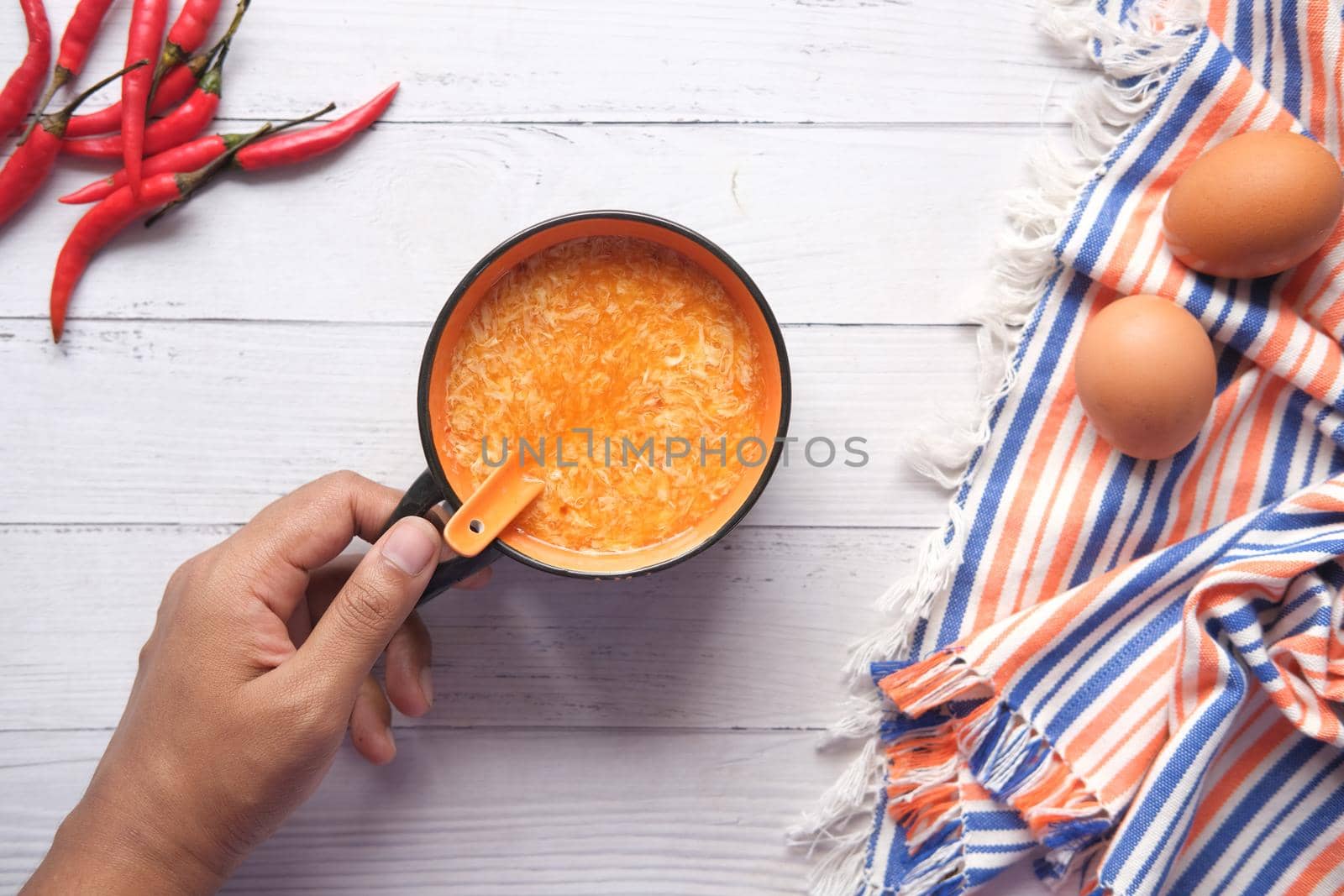 Traditional chinese egg drop soup with chili and egg on table