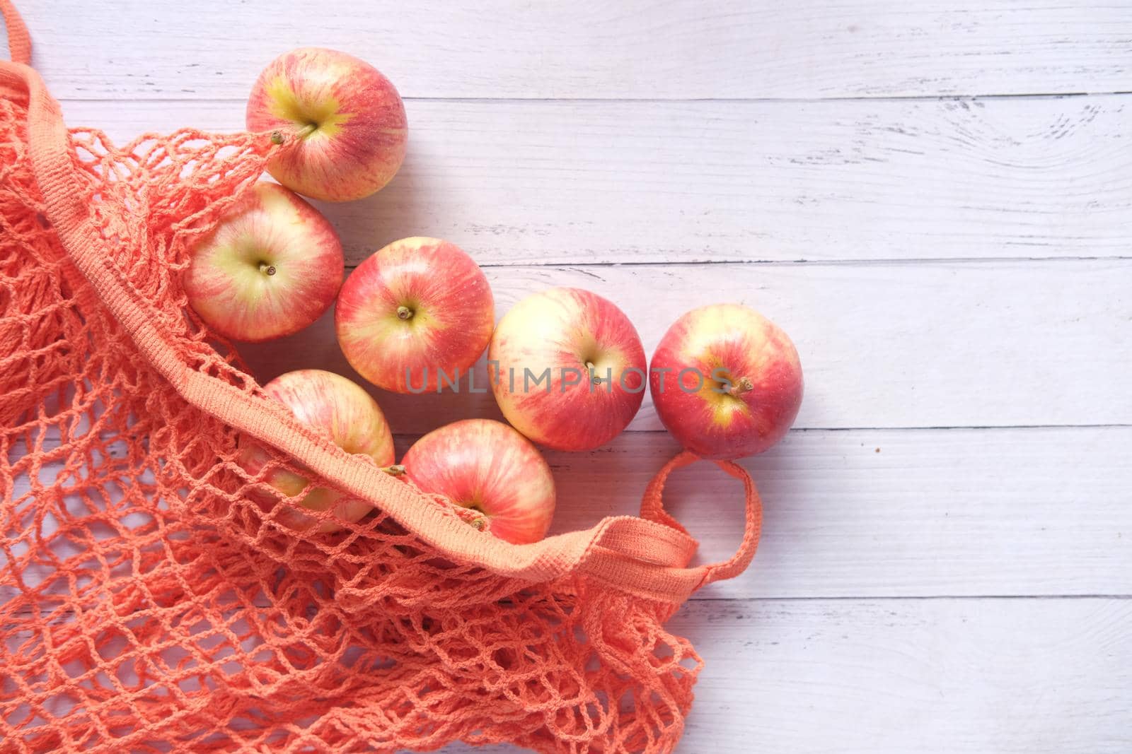 Close up of fresh apple in a shopping bag on wooden table